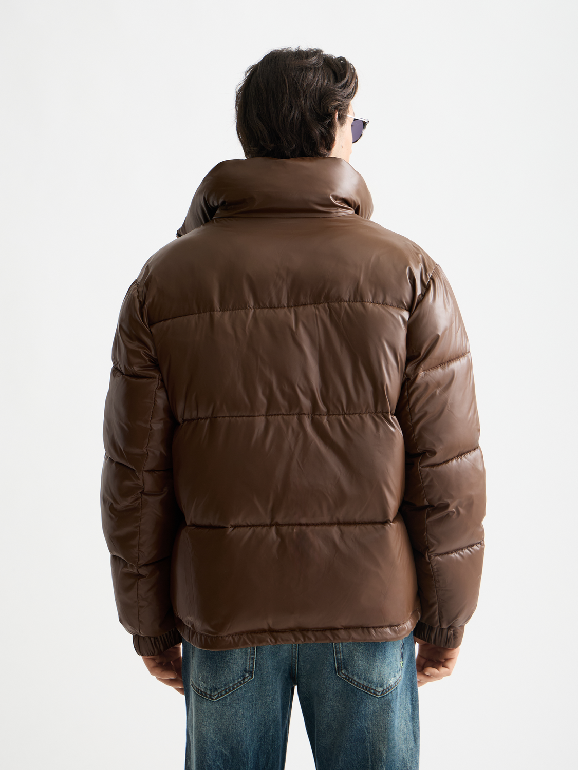 Black lacquer puffer jacket from SCOTCH & SODA with a high collar and quilted design, shown from the back.