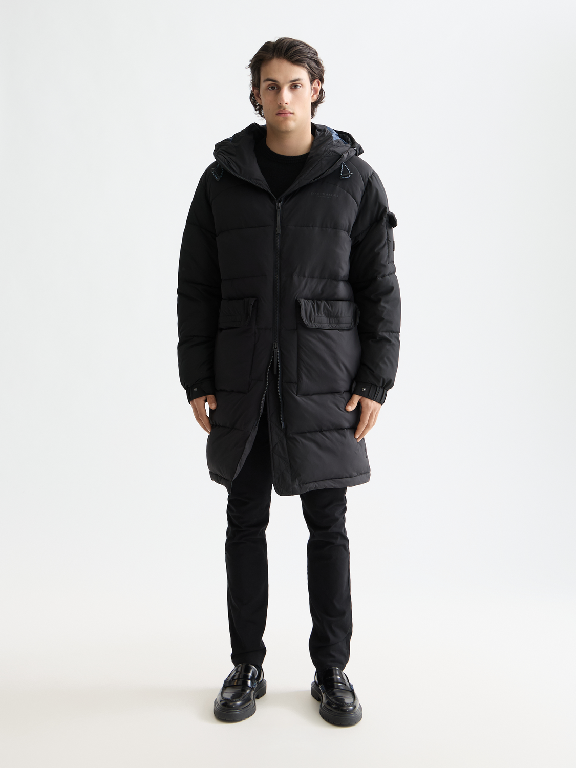 Long puffer jacket by Scotch & Soda, stylish winter jacket with a quilted design and high collar, displayed on a hanger.