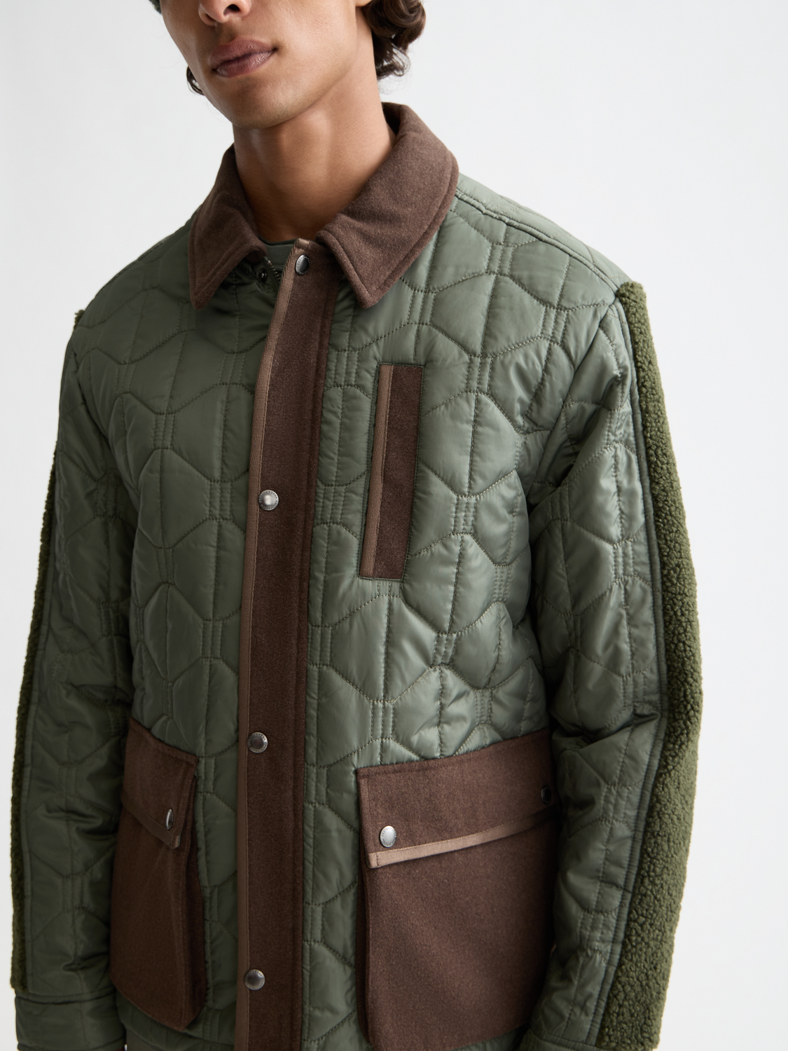 Scotch & Soda quilted military jacket with front pockets and button details, shown in a close-up view.