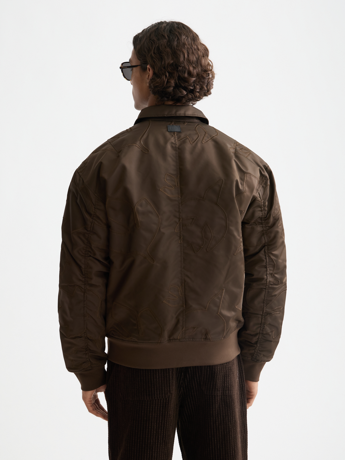 SCOTCH & SODA aviator bomber jacket shown from the back, featuring a classic silhouette with ribbed collar and quilted details.