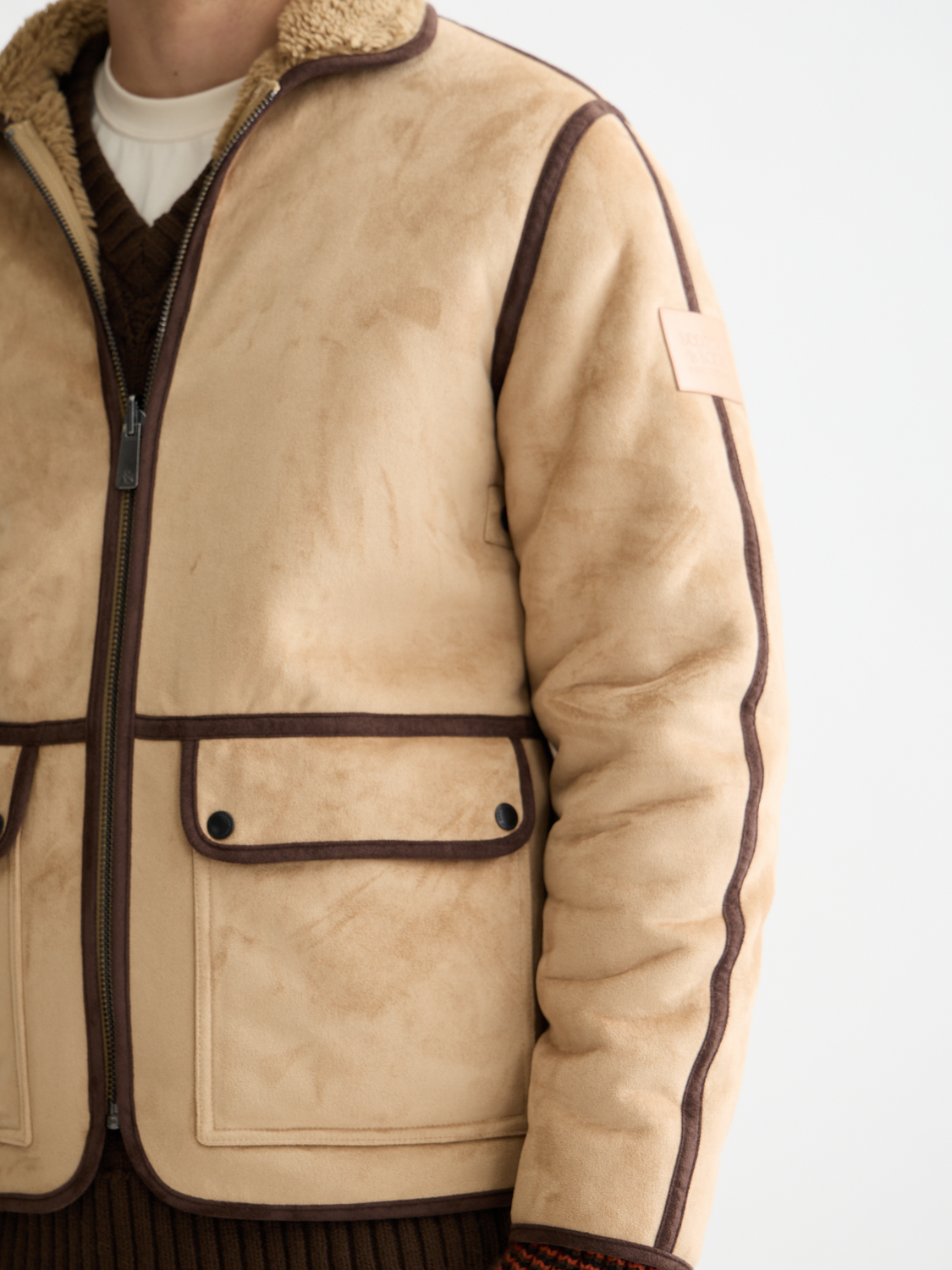 SCOTCH & SODA faux shearling jacket on a hanger, showcasing soft, plush exterior and stylish design for cold weather wear.