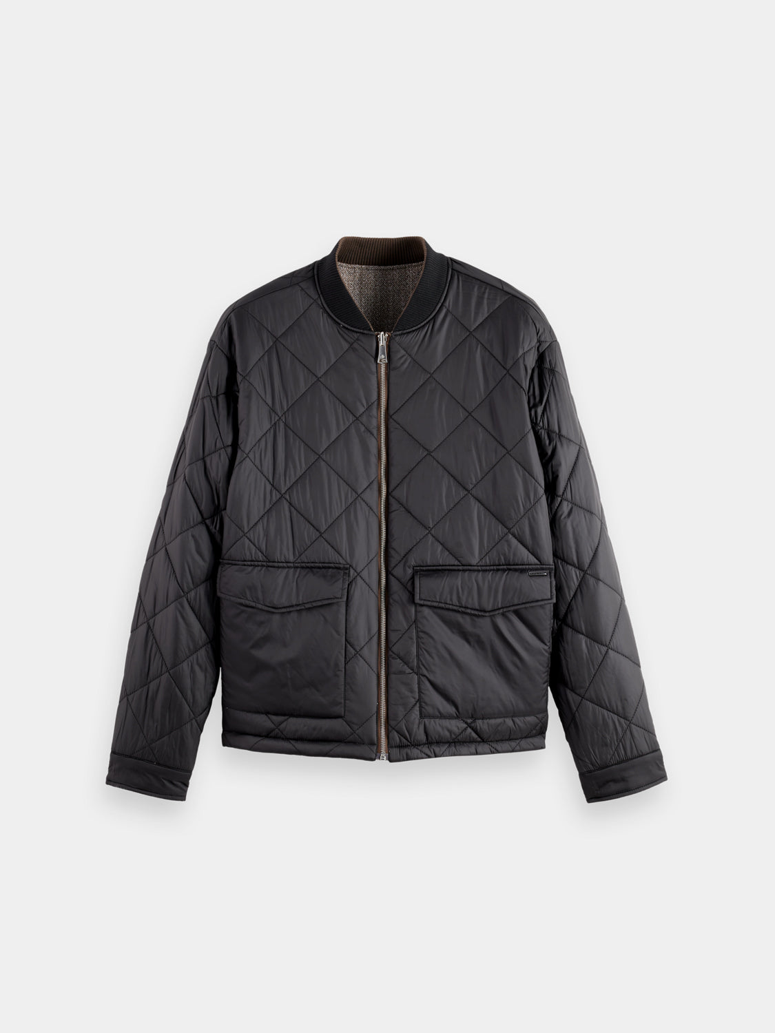 Reversible bomber jacket by Scotch & Soda featuring stylish design, shown with both sides visible in a casual outdoor setting.