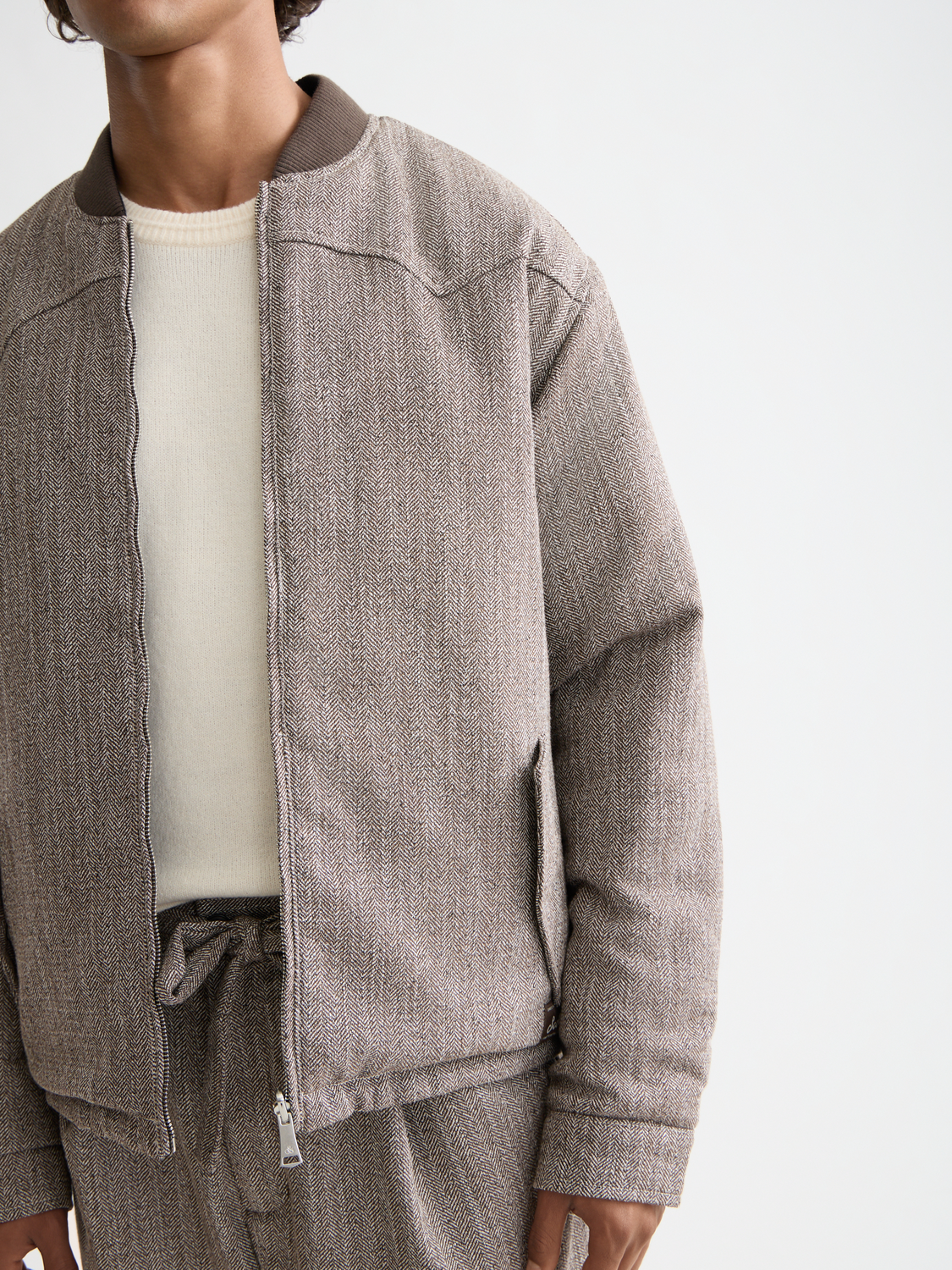 Reversible bomber jacket by Scotch & Soda, showing both solid and patterned sides, with front zipper and ribbed cuffs.