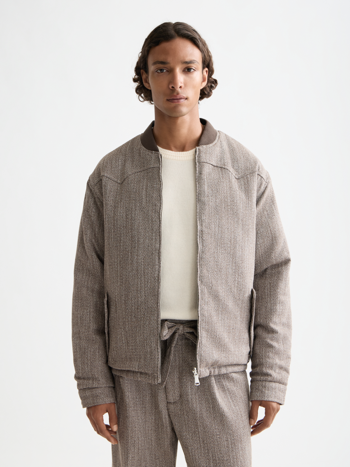 Reversible bomber jacket by Scotch & Soda showing both solid and patterned sides, front view with zip closure and stand collar.