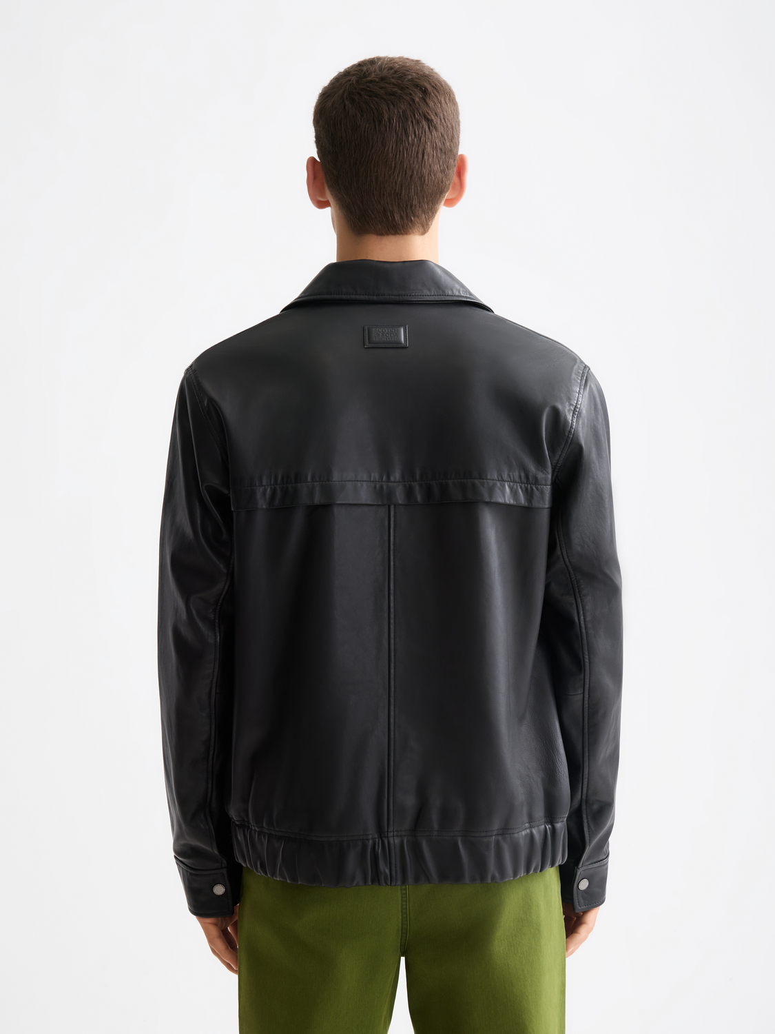 Black leather blouson jacket by Scotch & Soda, showcasing a stylish design with a textured leather finish and back detail.