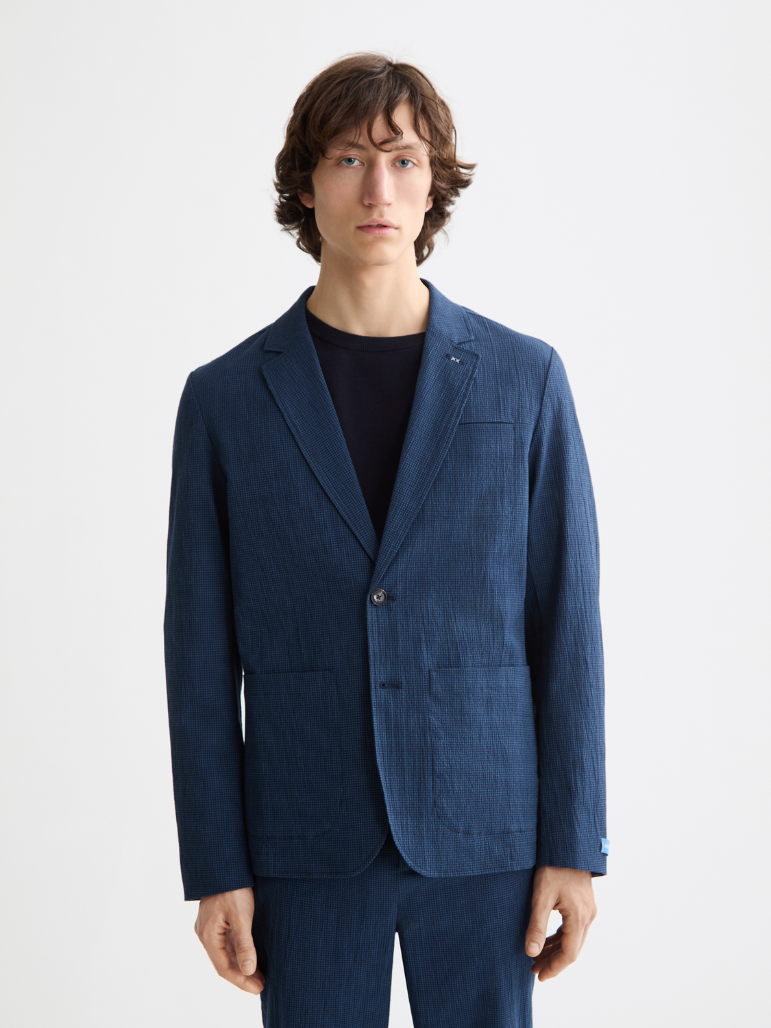 Scotch & Soda seersucker blazer in light blue with a notch lapel and tailored fit, displayed on a hanger.