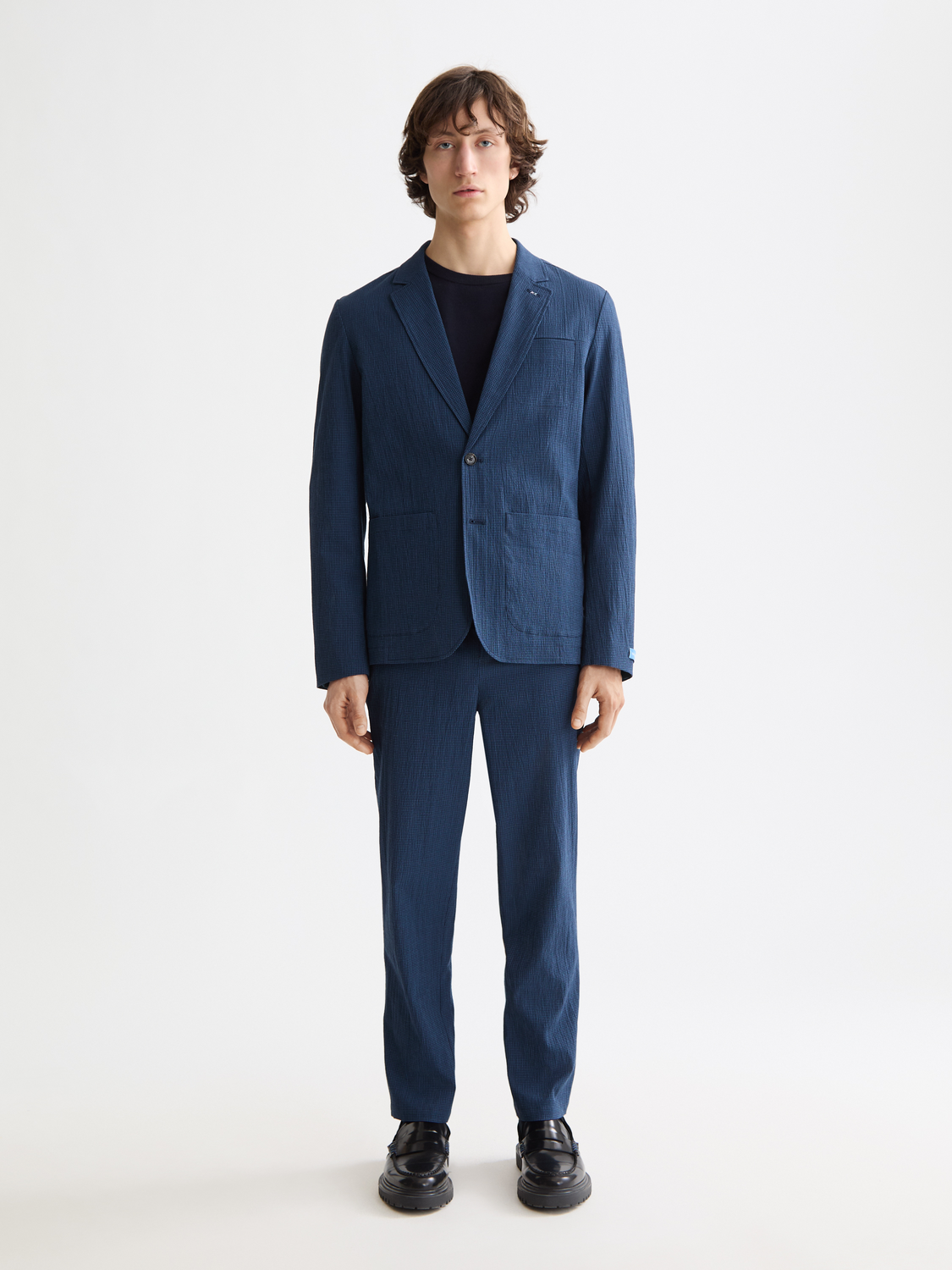 Seersucker blazer by Scotch & Soda, featuring a textured blue and white striped pattern, tailored fit, and classic lapel design.