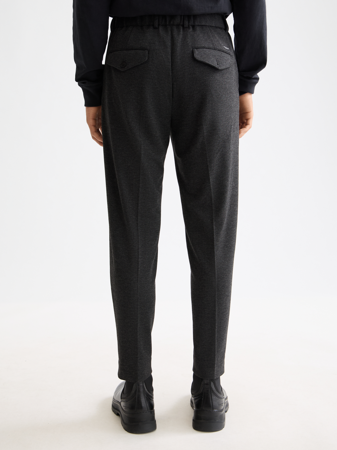 Back view of Scotch & Soda Finch tapered-fit pants in dark fabric, showing the tailored fit and back pockets.