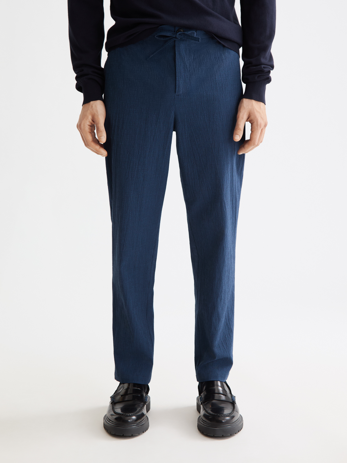 Scotch & Soda Finch tapered-fit pants in dark denim, showing front view with pockets and tapered leg design.