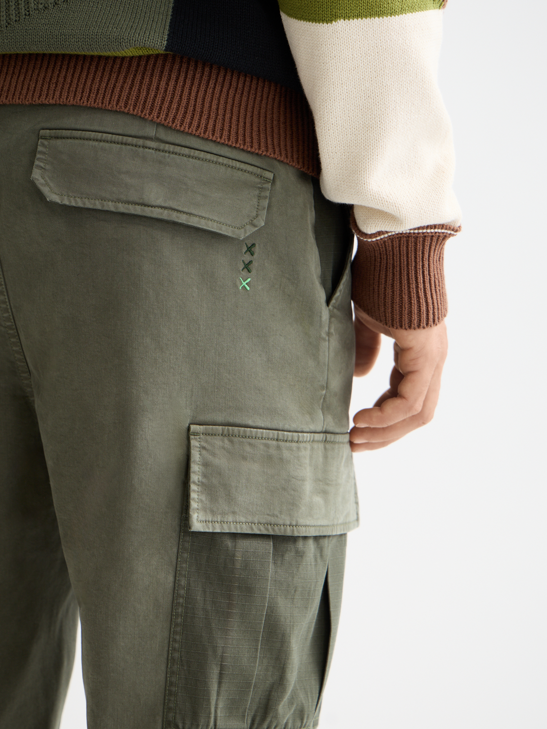 SCOTCH & SODA Harper cargo pants in neutral fabric with multiple pockets, displayed on a hanger.