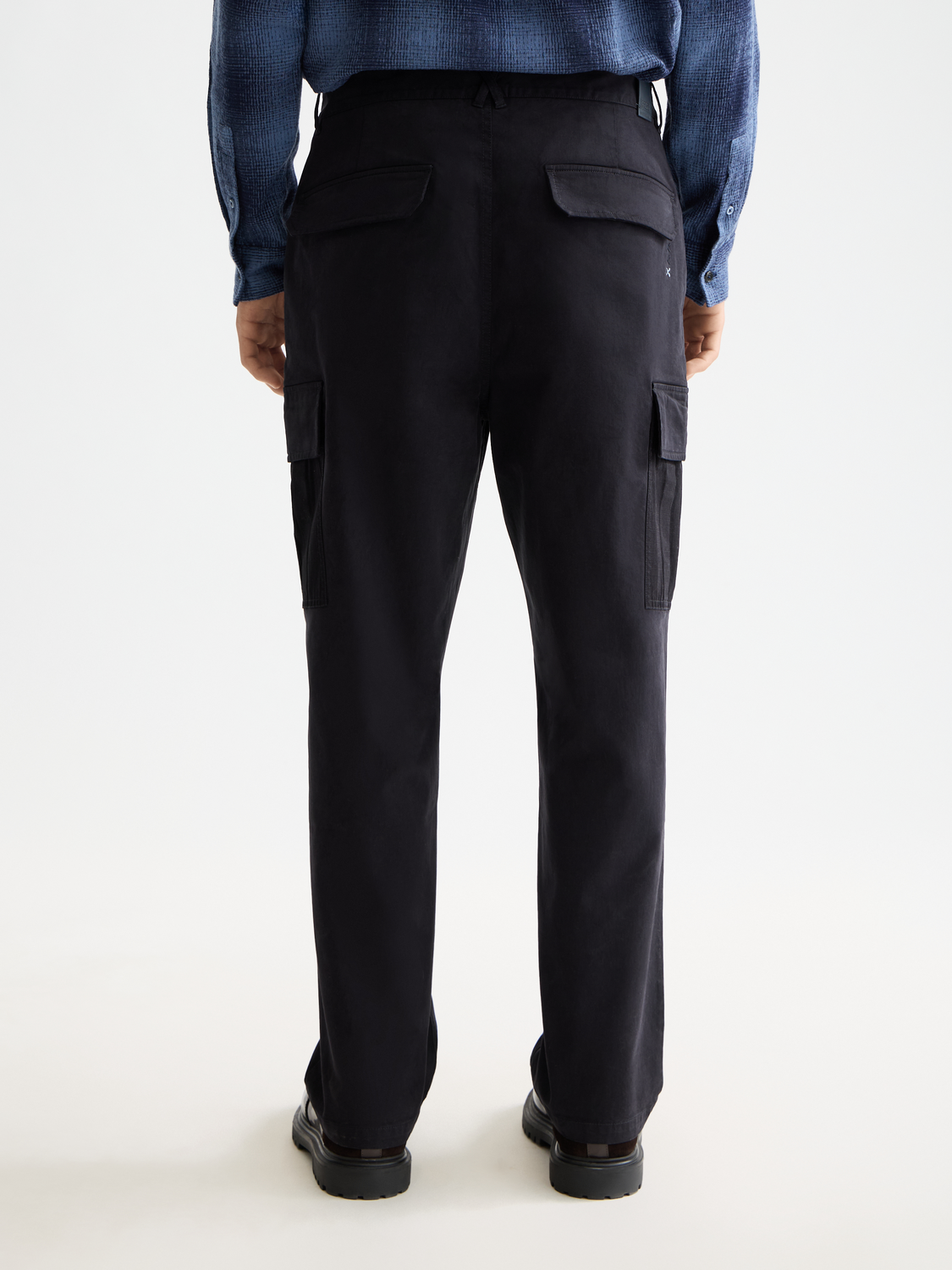 SCOTCH & SODA Harper cargo pants shown from the back, featuring multiple pockets and a relaxed fit in dark fabric.