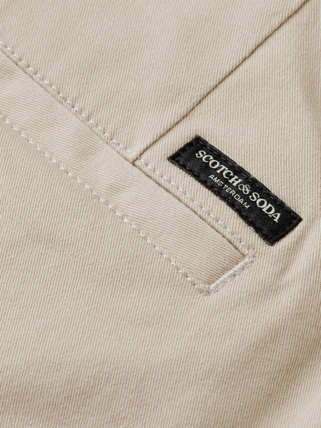 Slim-fit Mott chinos by Scotch & Soda in a neutral color, shown on a model with front and back views.