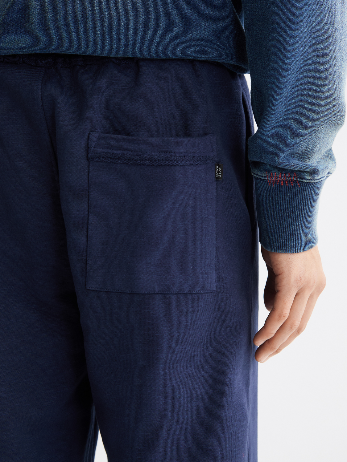 Garment-dyed sweatpants by Scotch & Soda, casual fit with soft fabric, shown laid flat with pockets and ribbed cuffs.