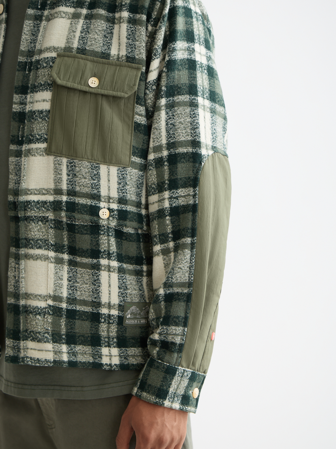 Long sleeve patchwork shirt by Scotch & Soda with mixed fabric patterns and vibrant colors, displayed on a hanger.