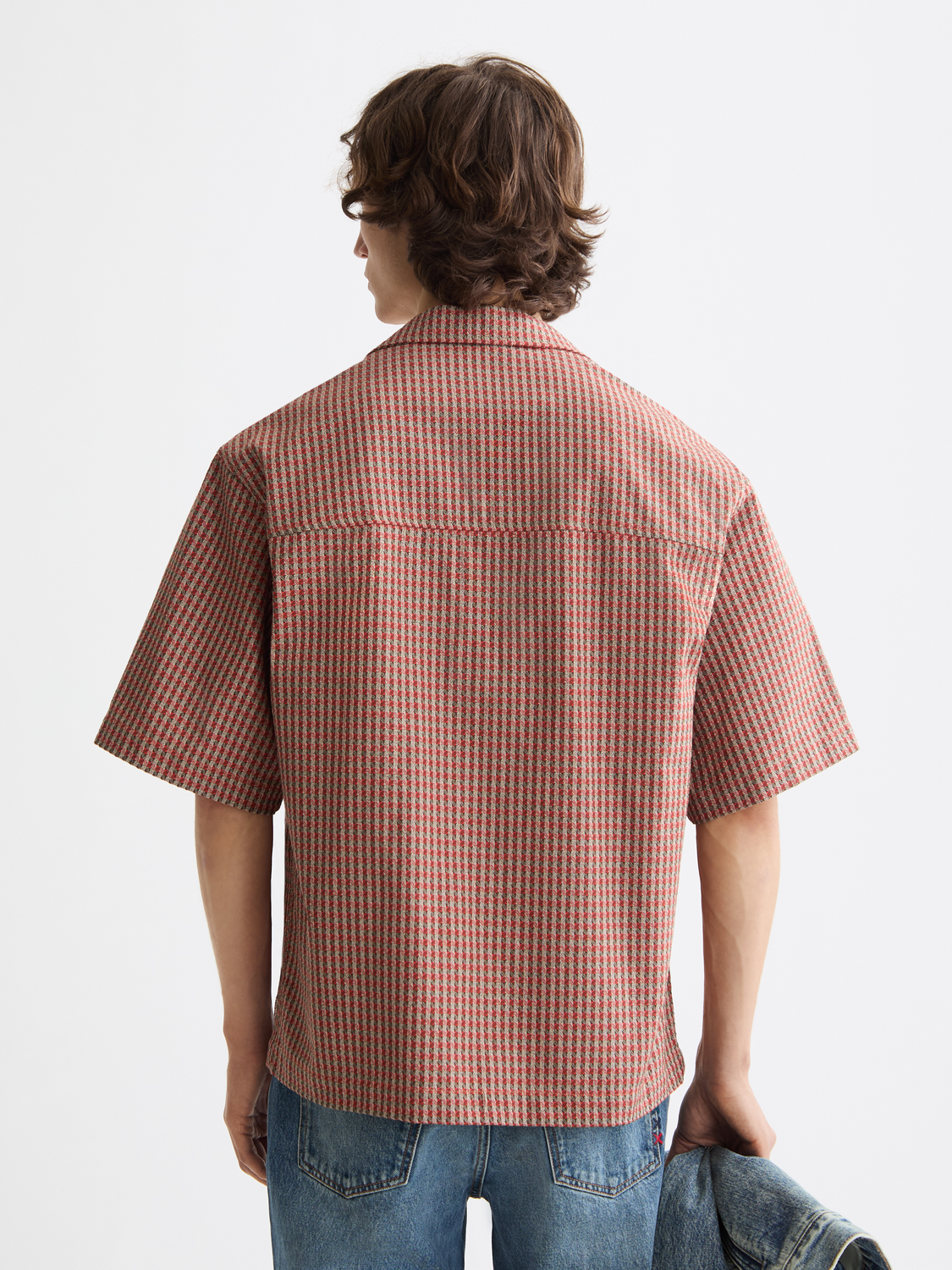 Printed short-sleeved shirt by Scotch & Soda with colorful pattern, shown from the back on a male model.