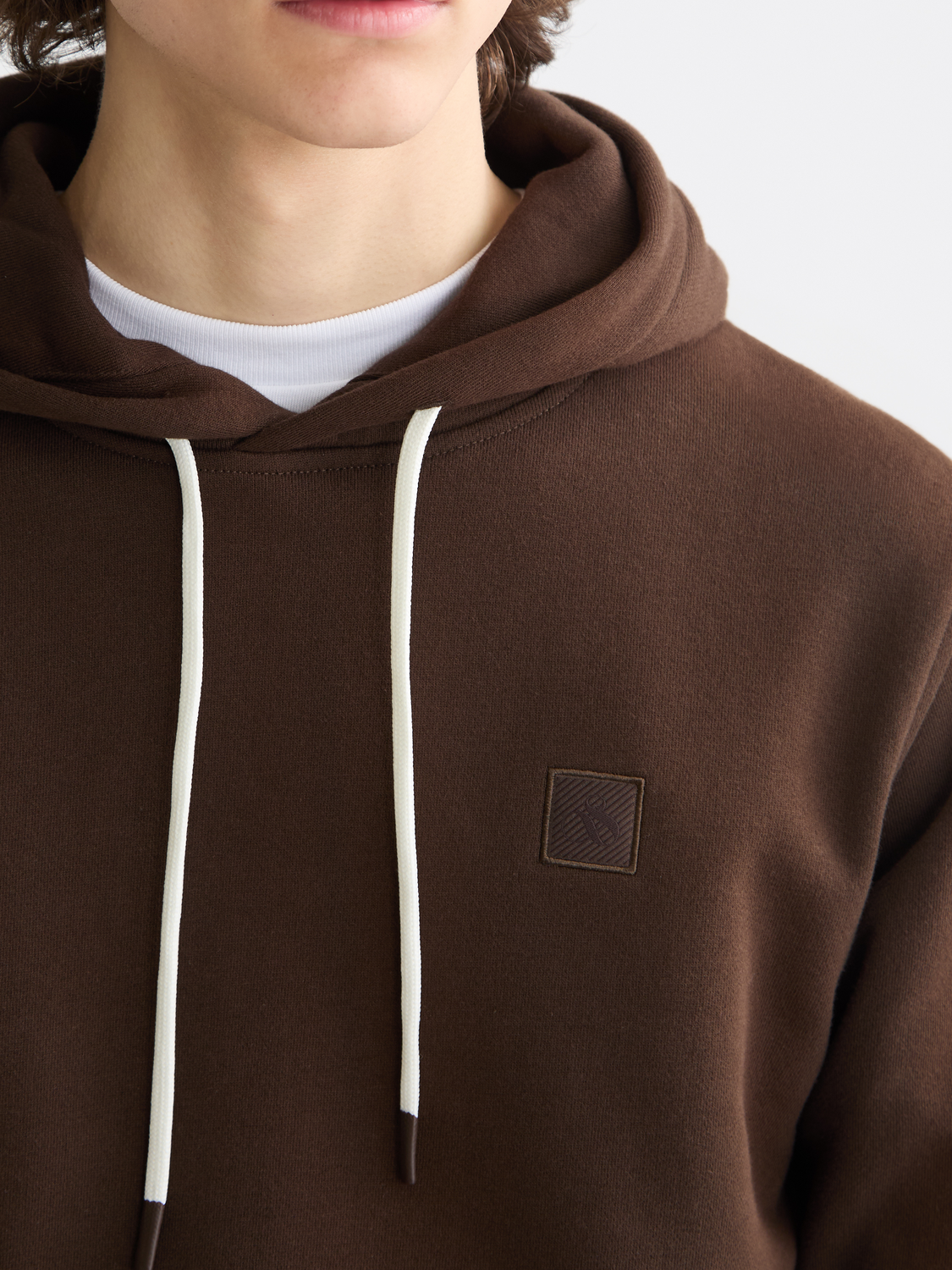Gray hoodie with a prominent logo badge from Scotch & Soda, featuring a relaxed fit and soft fabric for comfortable wear.
