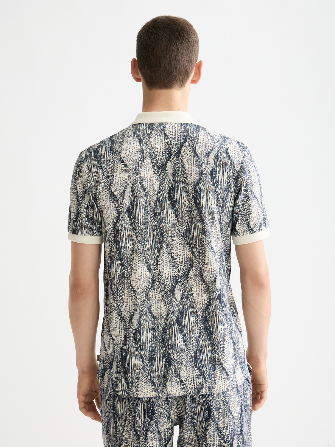 Printed Scotch & Soda polo shirt with colorful pattern, short sleeves, and classic collar for men's casual style.