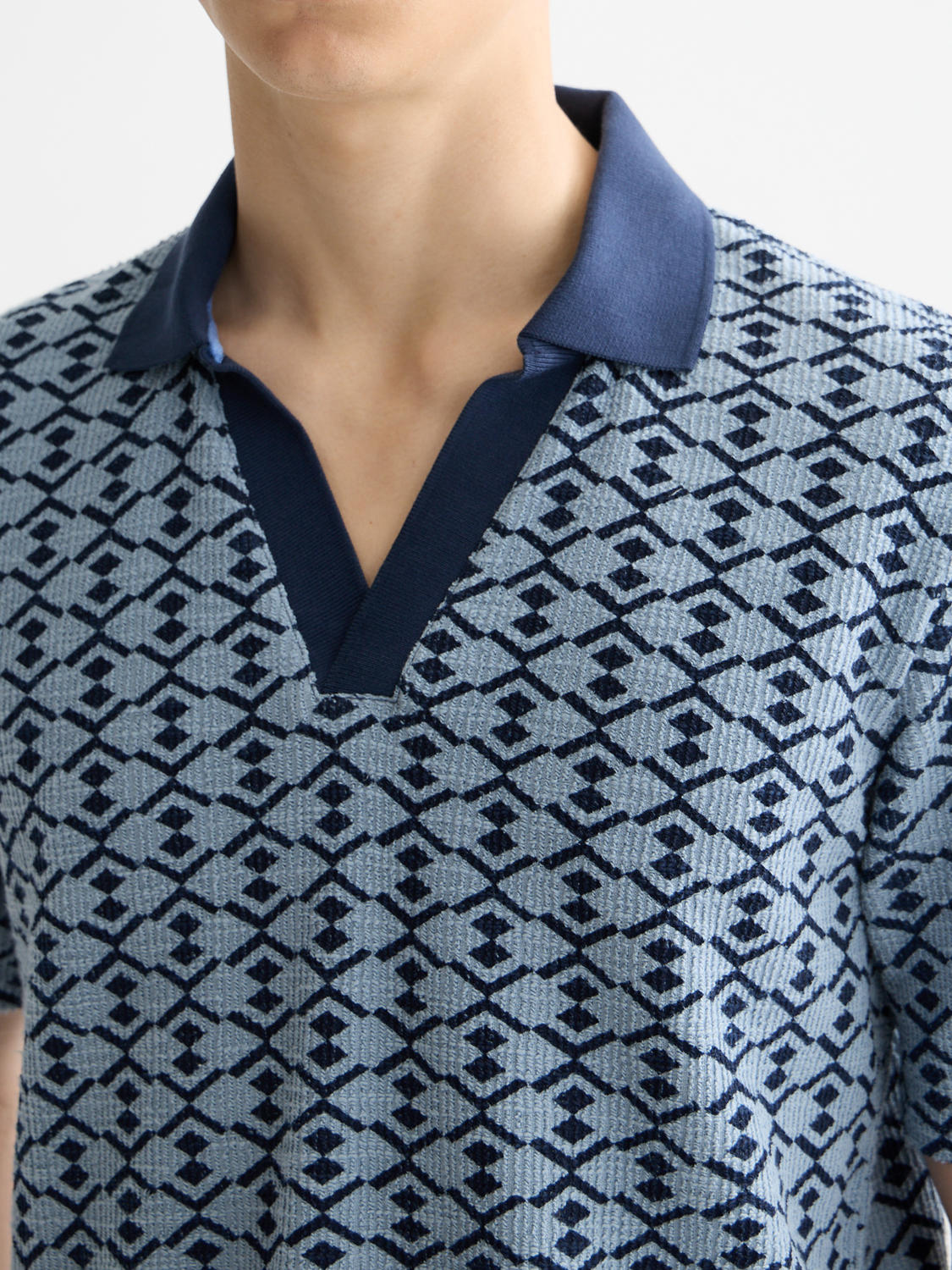 Scotch & Soda towelling polo shirt in light blue with a classic collar and short sleeves, displayed on a hanger.