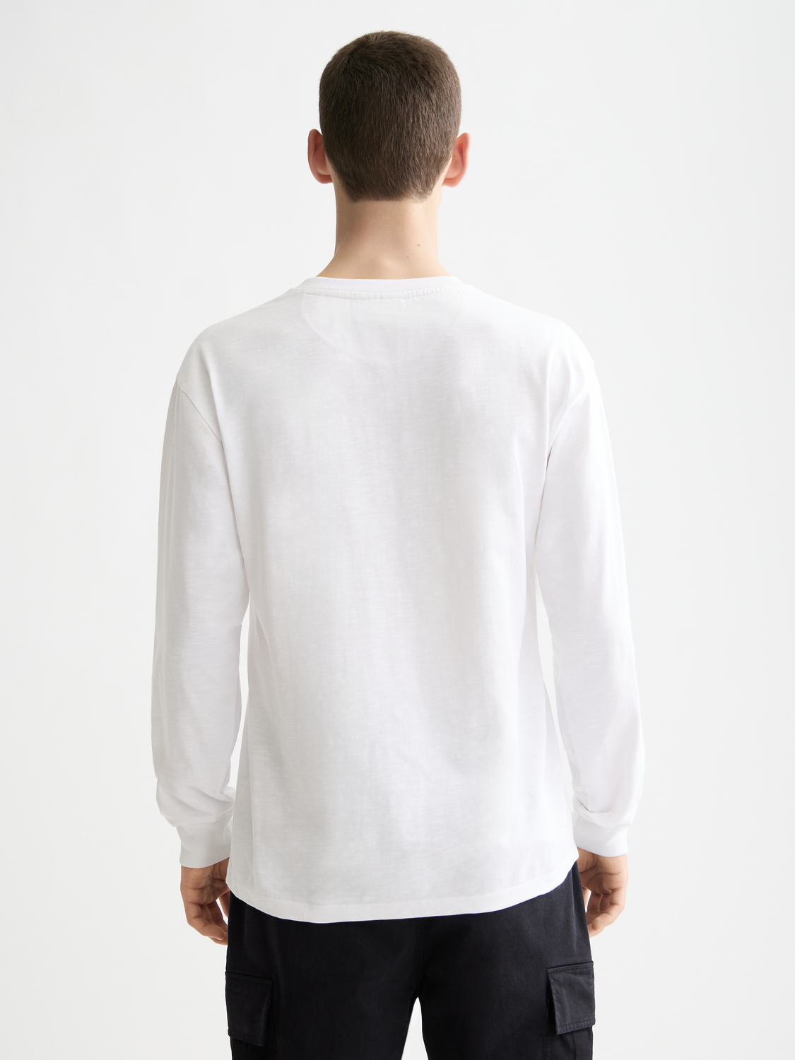 Long sleeve Scotch & Soda Slub Henley T-shirt in black, featuring a textured fabric and buttoned neckline on a model.