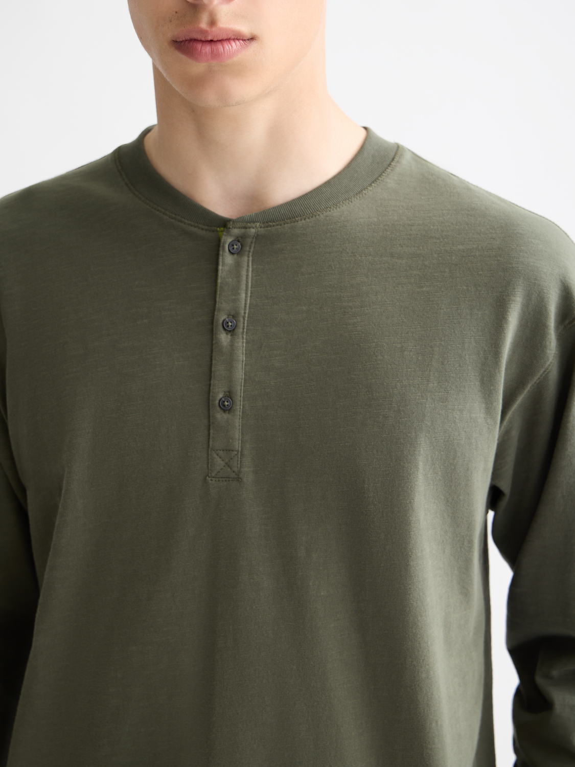 Long sleeve Scotch & Soda Slub Henley t-shirt in a muted color, featuring a buttoned collar and textured fabric.