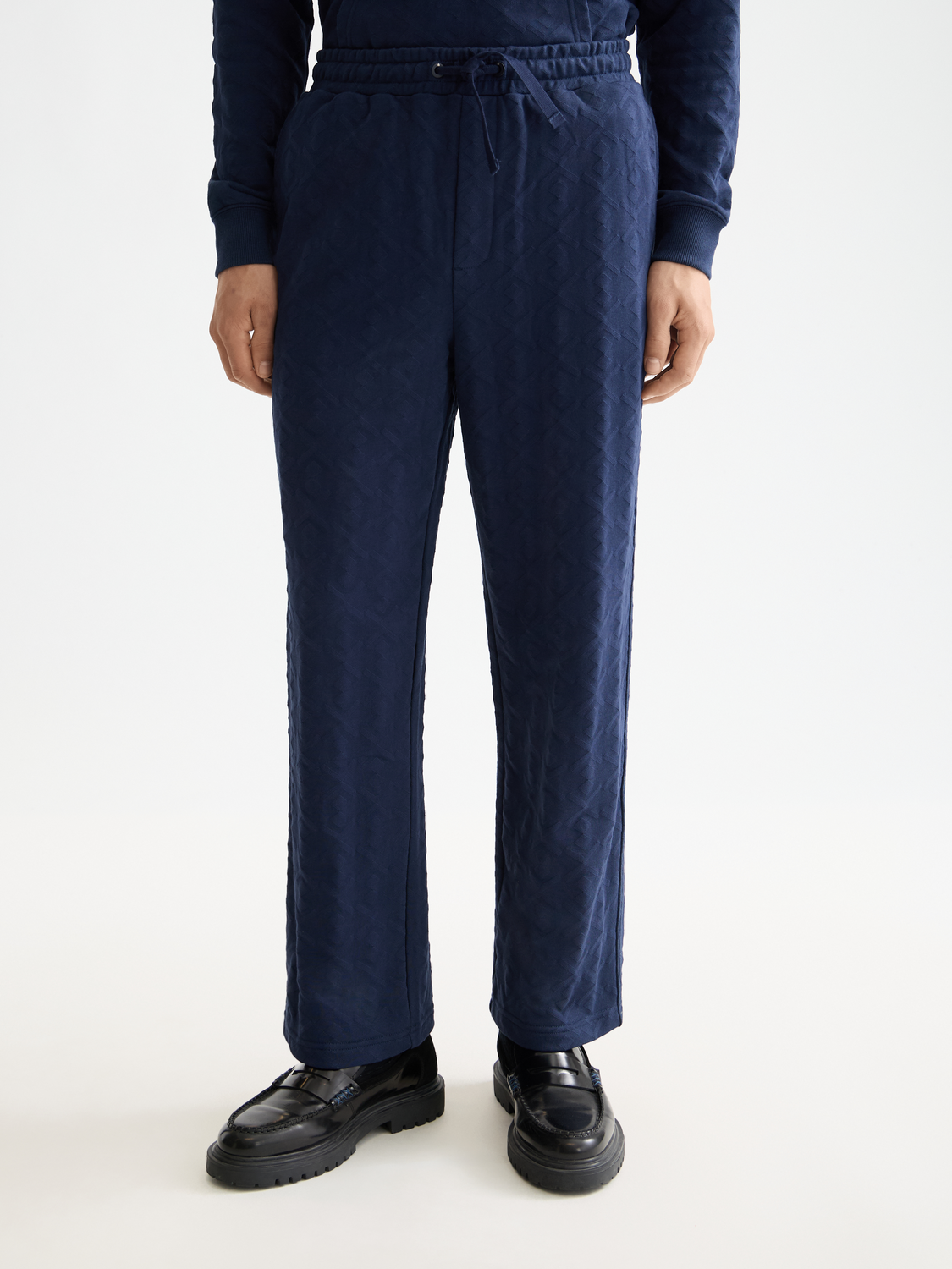SCOTCH & SODA jacquard terry sweatpants in navy with a relaxed fit and elastic waistband, displayed on a hanger.