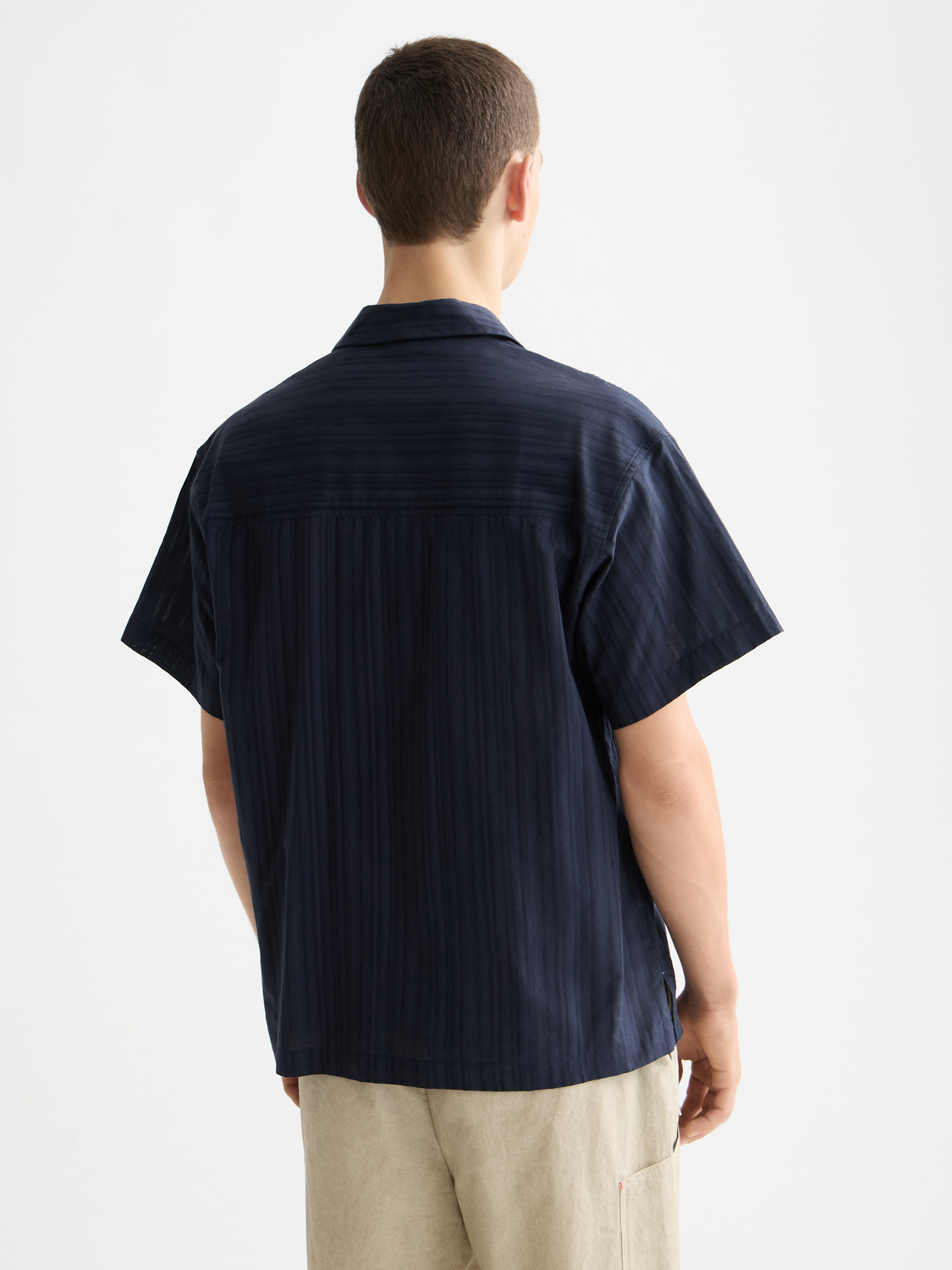Striped short-sleeved shirt by Scotch & Soda, showing the back view with vertical blue and white stripes and collar details.