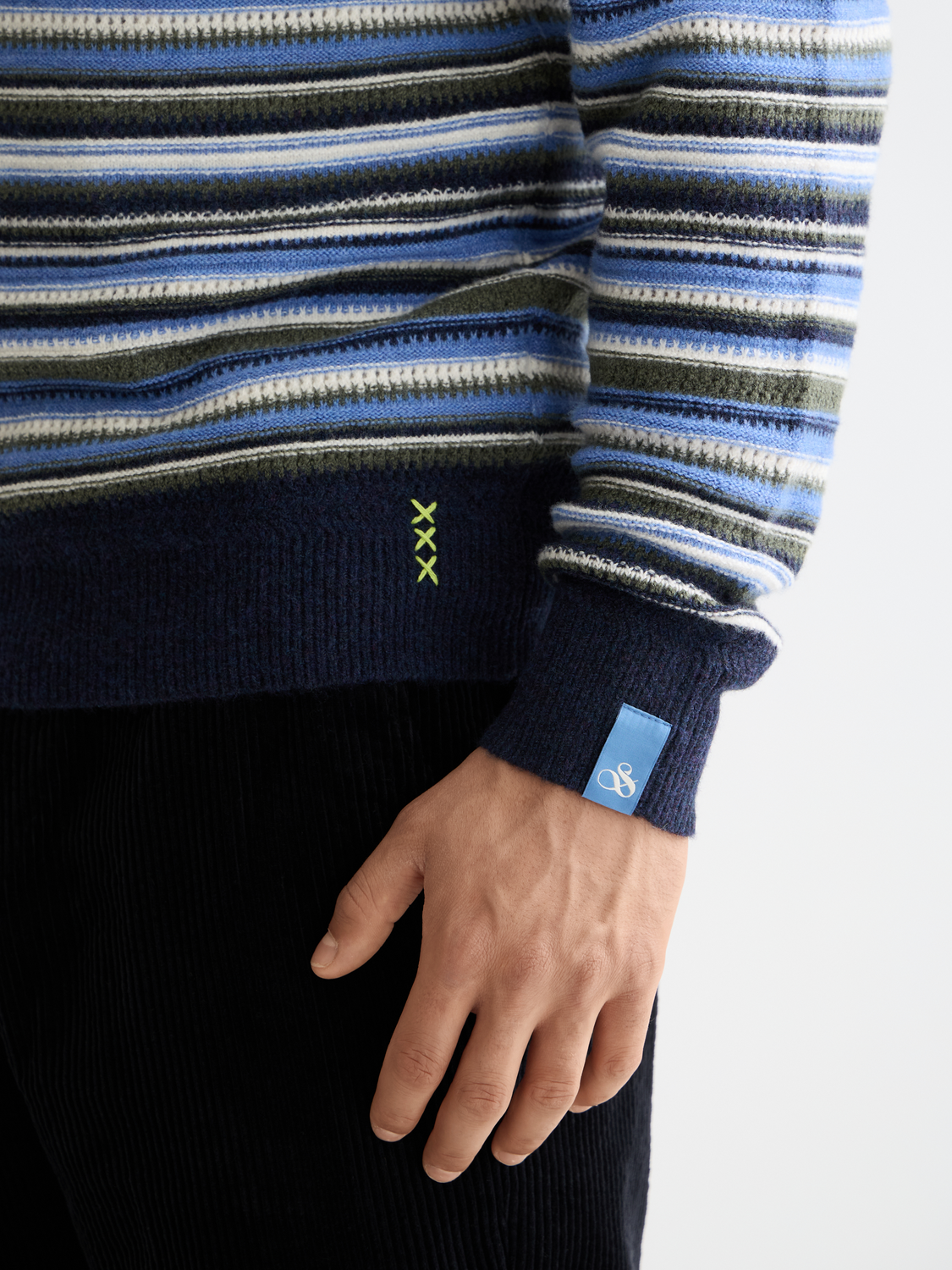 Striped SCOTCH & SODA knitwear pullover with multicolor pattern and ribbed cuffs on a mannequin.