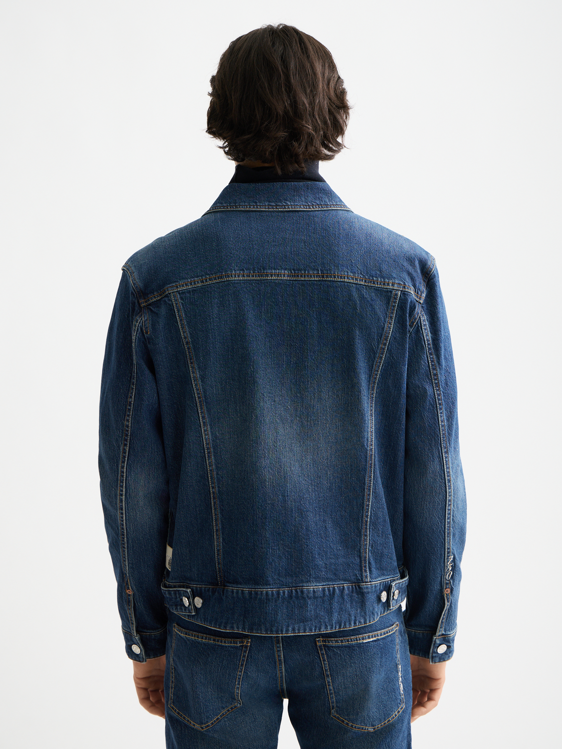 Dark blue Scotch & Soda denim trucker jacket with classic collar and button-front, shown from the back.