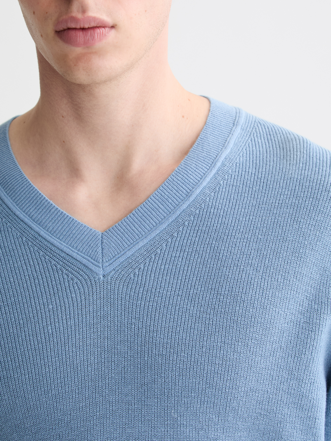 SCOTCH & SODA V-neck knitwear pullover in cozy fabric, close-up shot showing its classic V-neck design and textured knit pattern.