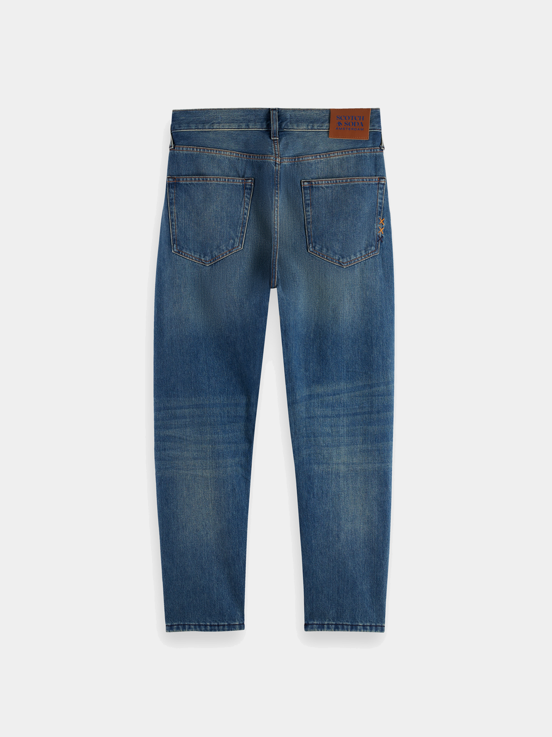 Dark blue Dean tapered denim jeans by Scotch & Soda, showing the fit and style of the tapered cut and classic denim fabric.