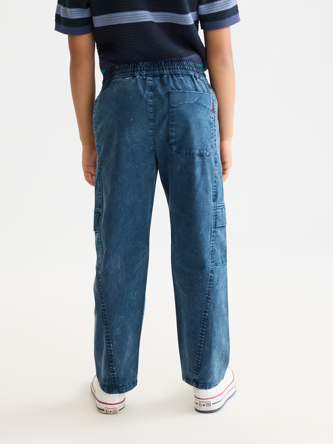 Kids' garment-dyed pants by Scotch & Soda, showing the back view with relaxed fit and soft, colorful fabric.