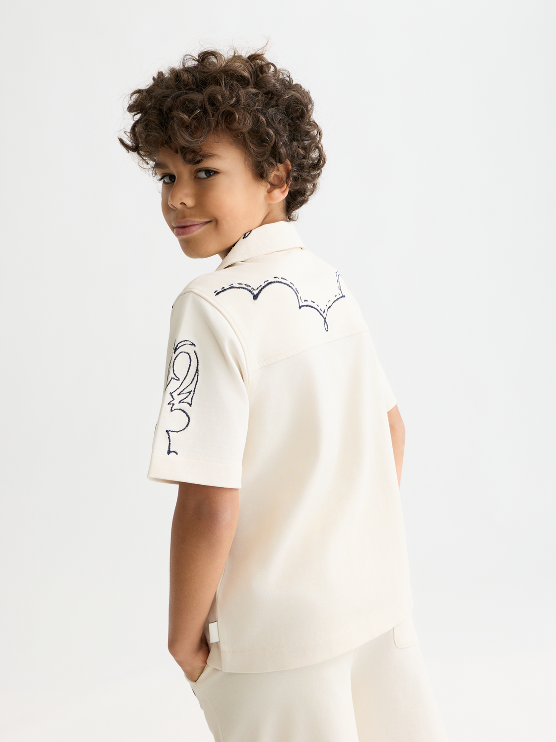 Kids' printed short-sleeved shirt by Scotch & Soda, featuring colorful patterns and a casual fit, shown from the back.