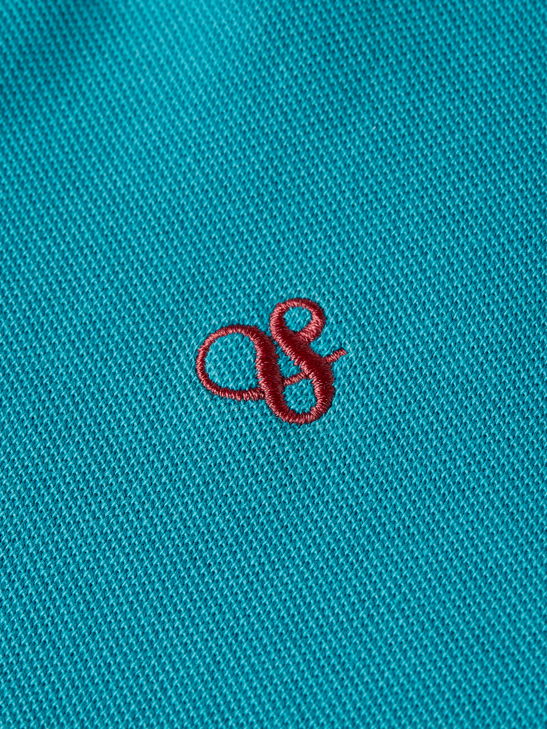 Kids' garment-dyed pique polo shirt by Scotch & Soda, featuring a classic collar and short sleeves in vibrant colors.