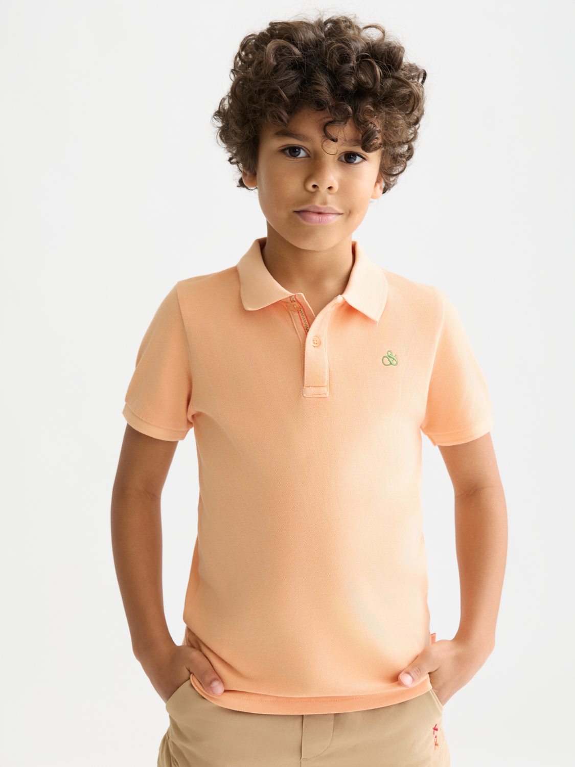 Kids garment-dyed pique polo shirt by Scotch & Soda, featuring a classic collar and short sleeves in vibrant color.