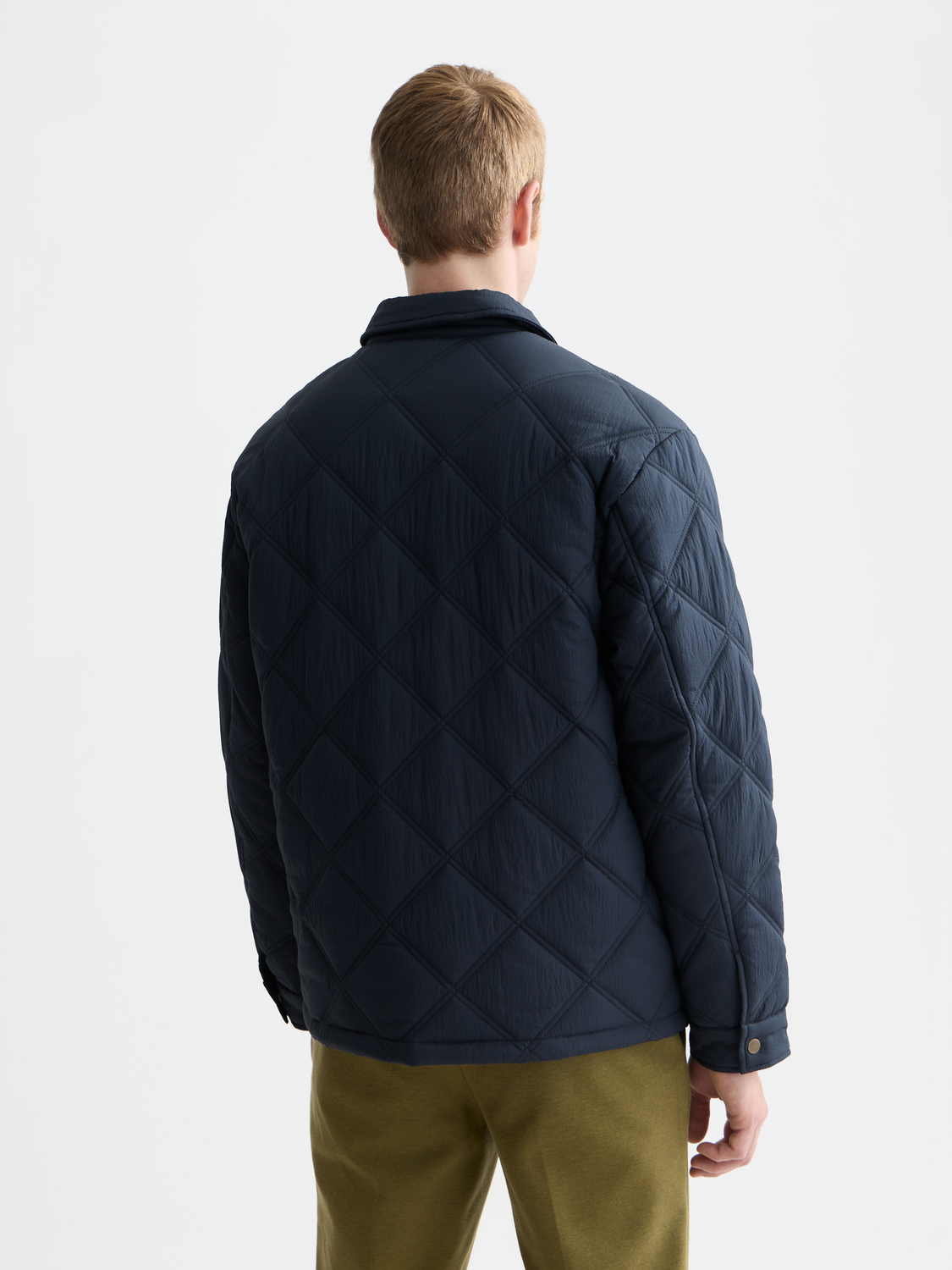 Scotch & Soda quilted jacket in black with a zip front and padded design, displayed on a model.