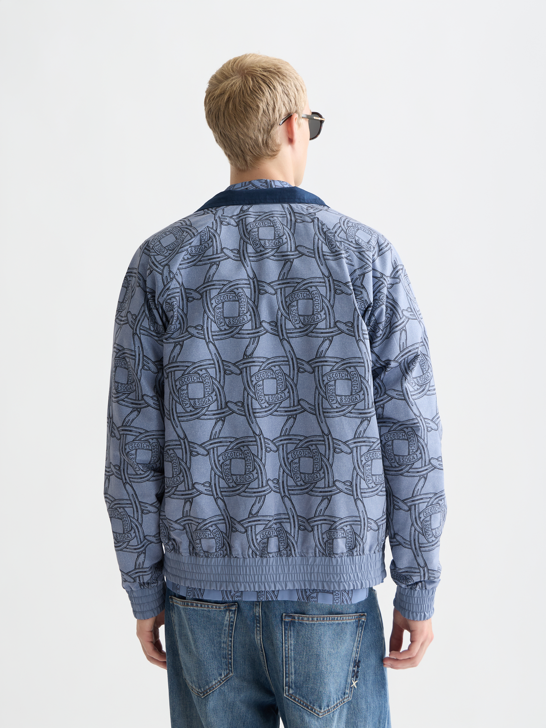 Reversible printed jacket by Scotch & Soda showing vibrant pattern on one side and solid color on the other.