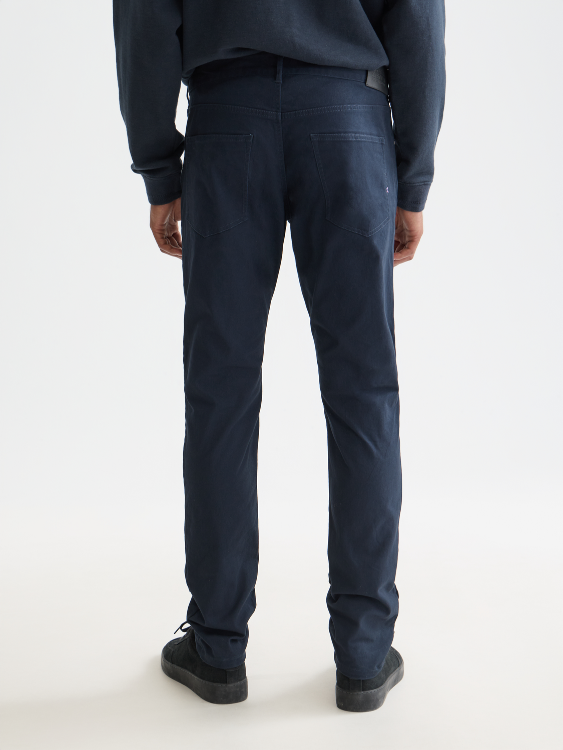 SCOTCH & SODA Ralston slim-fit pants in dark fabric, shown from back with a clean, tailored look and subtle stitching details.