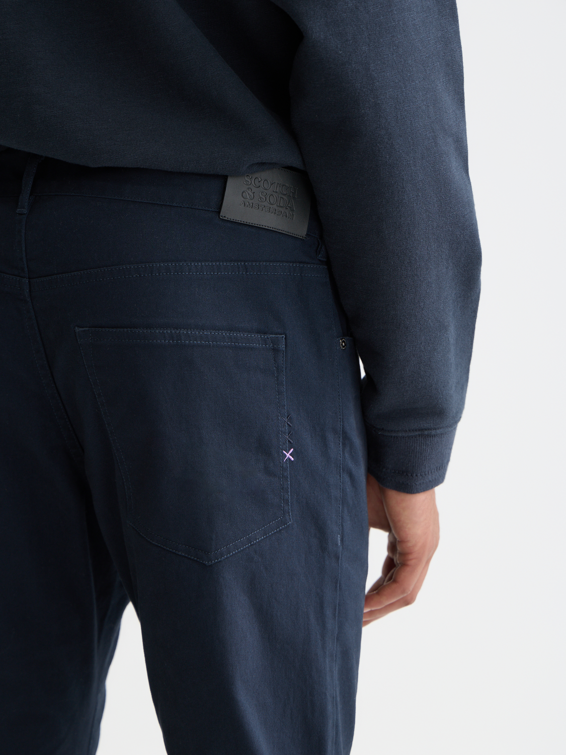 Slim-fit Ralston pants by Scotch & Soda, shown in navy, featuring a tailored design with front pockets and belt loops.