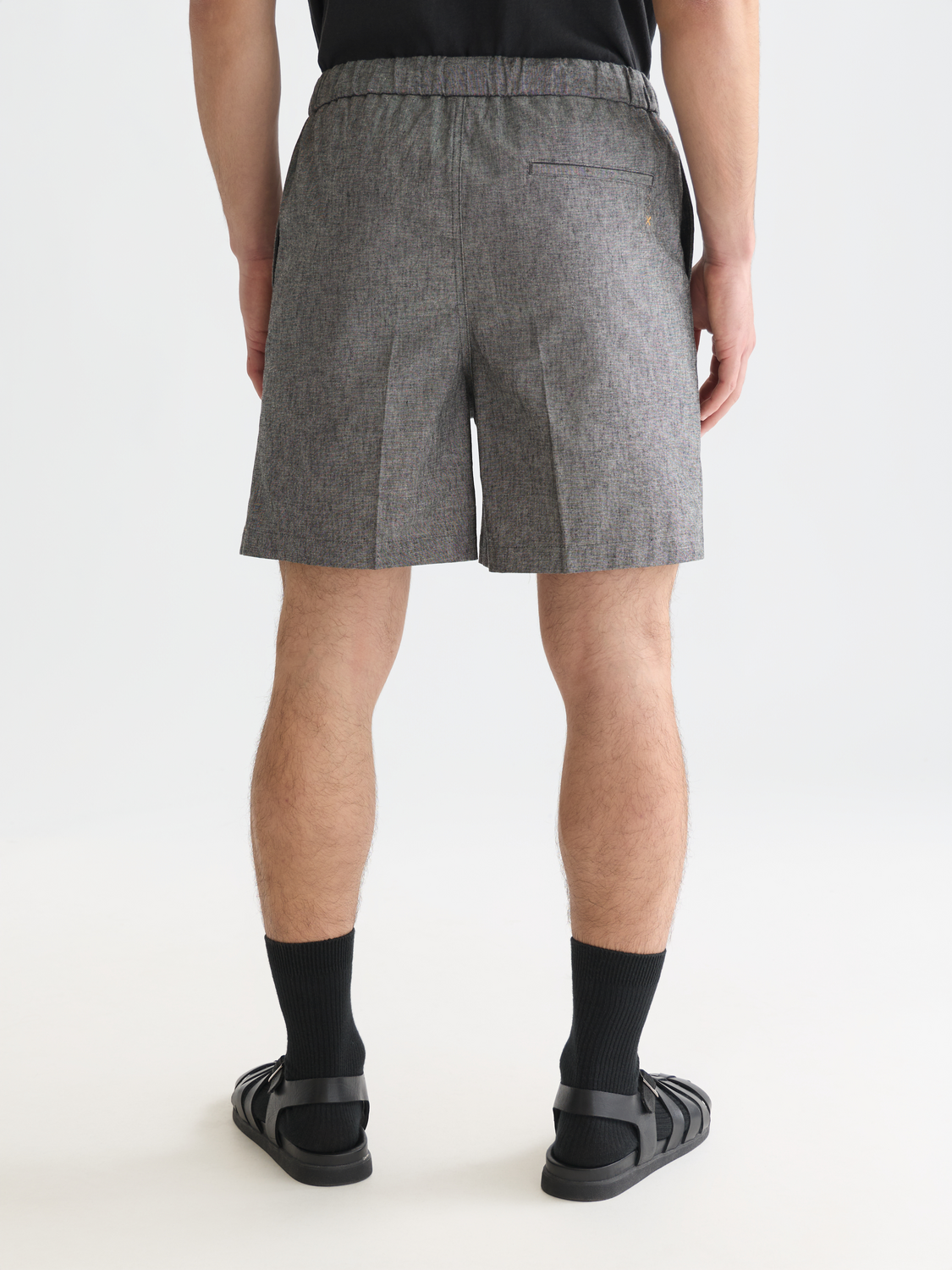 Back view of tailored Scotch & Soda shorts in dark color, showcasing clean stitching and classic design details.