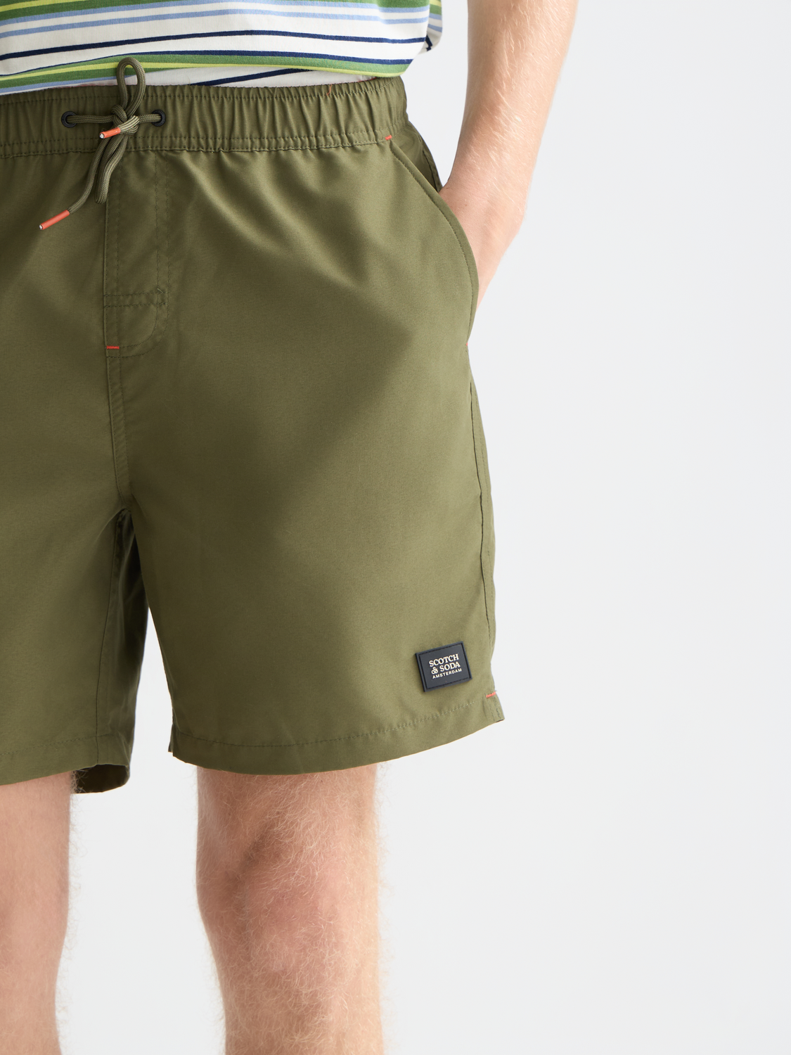 Mid-length Scotch & Soda swim shorts in vibrant blue with floral pattern, tailored fit, and elastic waistband.