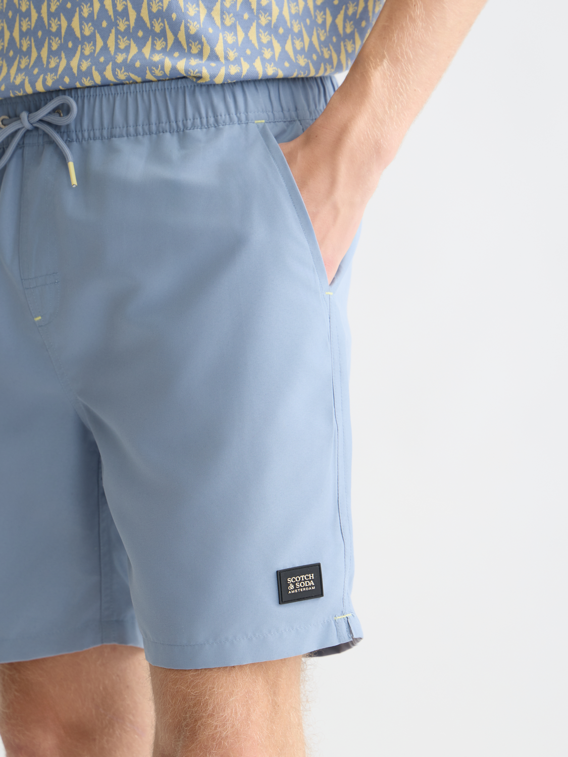 Mid-length Scotch & Soda swim shorts with a colorful pattern, displayed flat on a white background, ideal for summer swimwear.