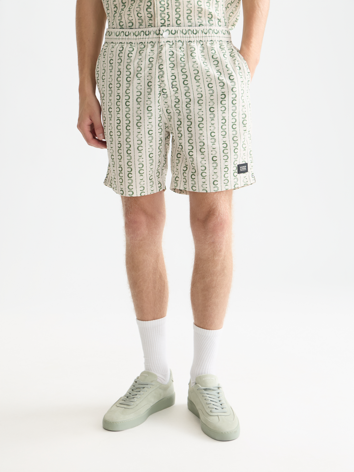 Printed Scotch & Soda swimshorts with vibrant colorful pattern, displayed on a flat lay for stylish summer swimwear.
