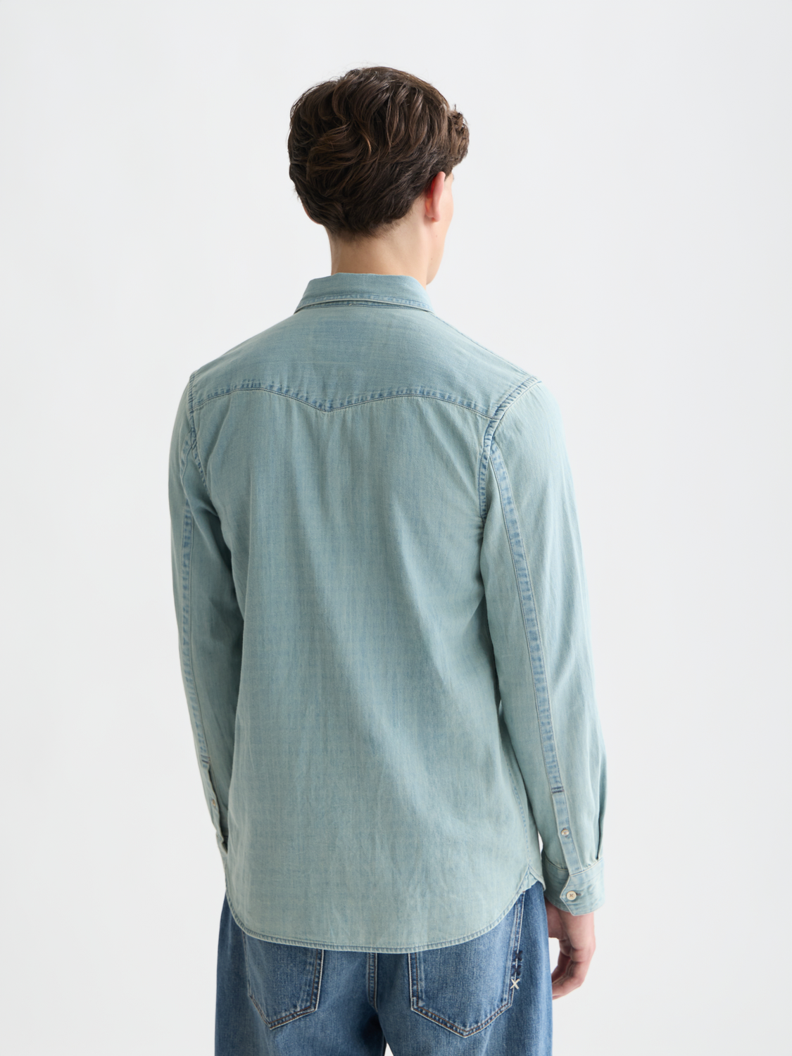 Light blue Scotch & Soda Western denim shirt with long sleeves and back yoke detail, displayed on a white background.