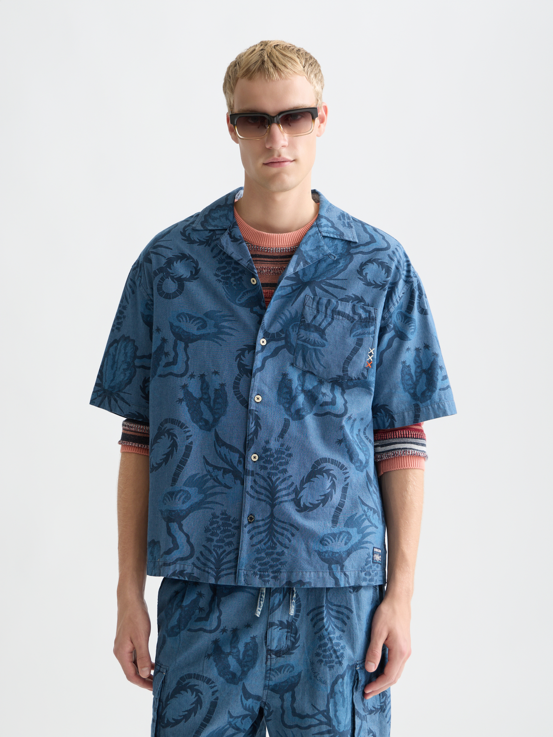 Printed short-sleeved shirt by Scotch & Soda with colorful design, shown on a hanger against a plain background.