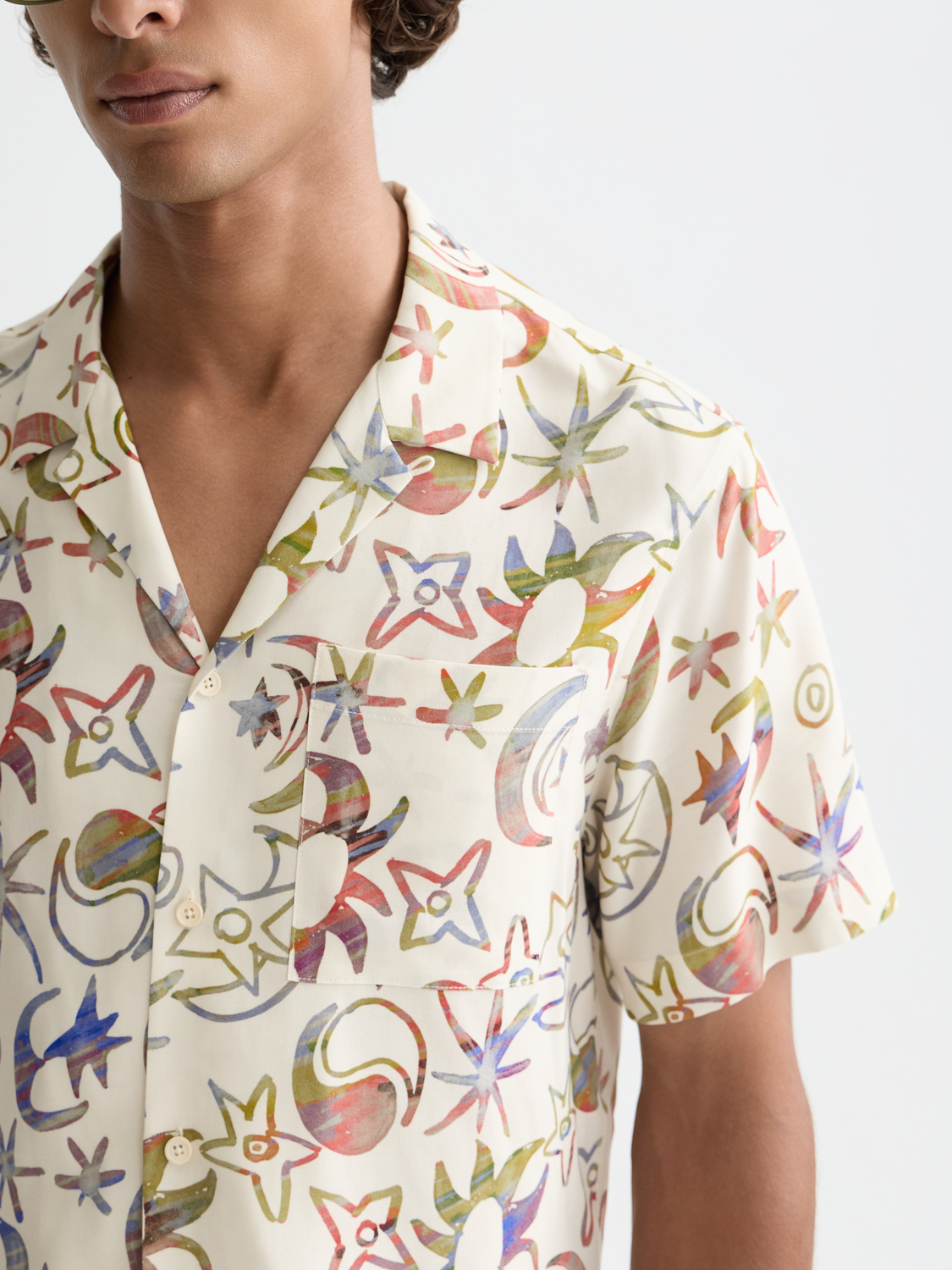 Printed short-sleeved shirt by Scotch & Soda featuring vibrant patterns and casual fit, displayed on a hanger.