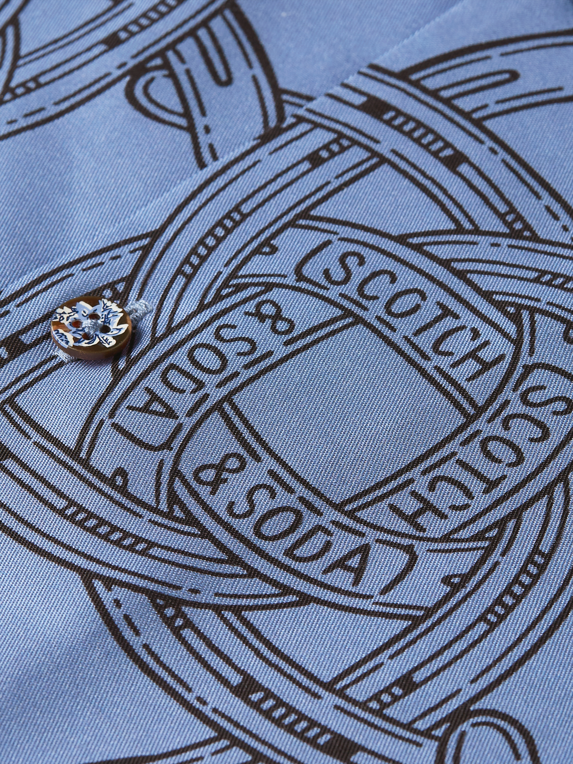 Printed short-sleeved shirt from Scotch & Soda featuring vibrant patterns and a casual fit, displayed on a hanger.