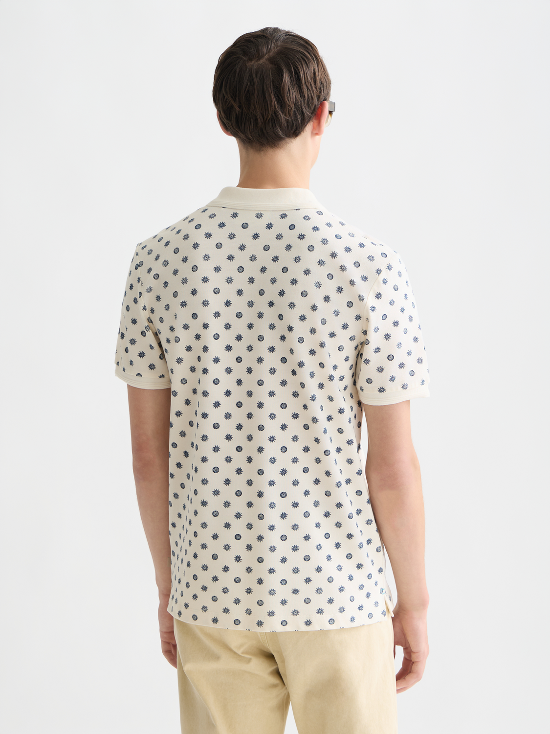 Printed Scotch & Soda polo shirt with a colorful pattern, short sleeves, and classic collar on a mannequin.