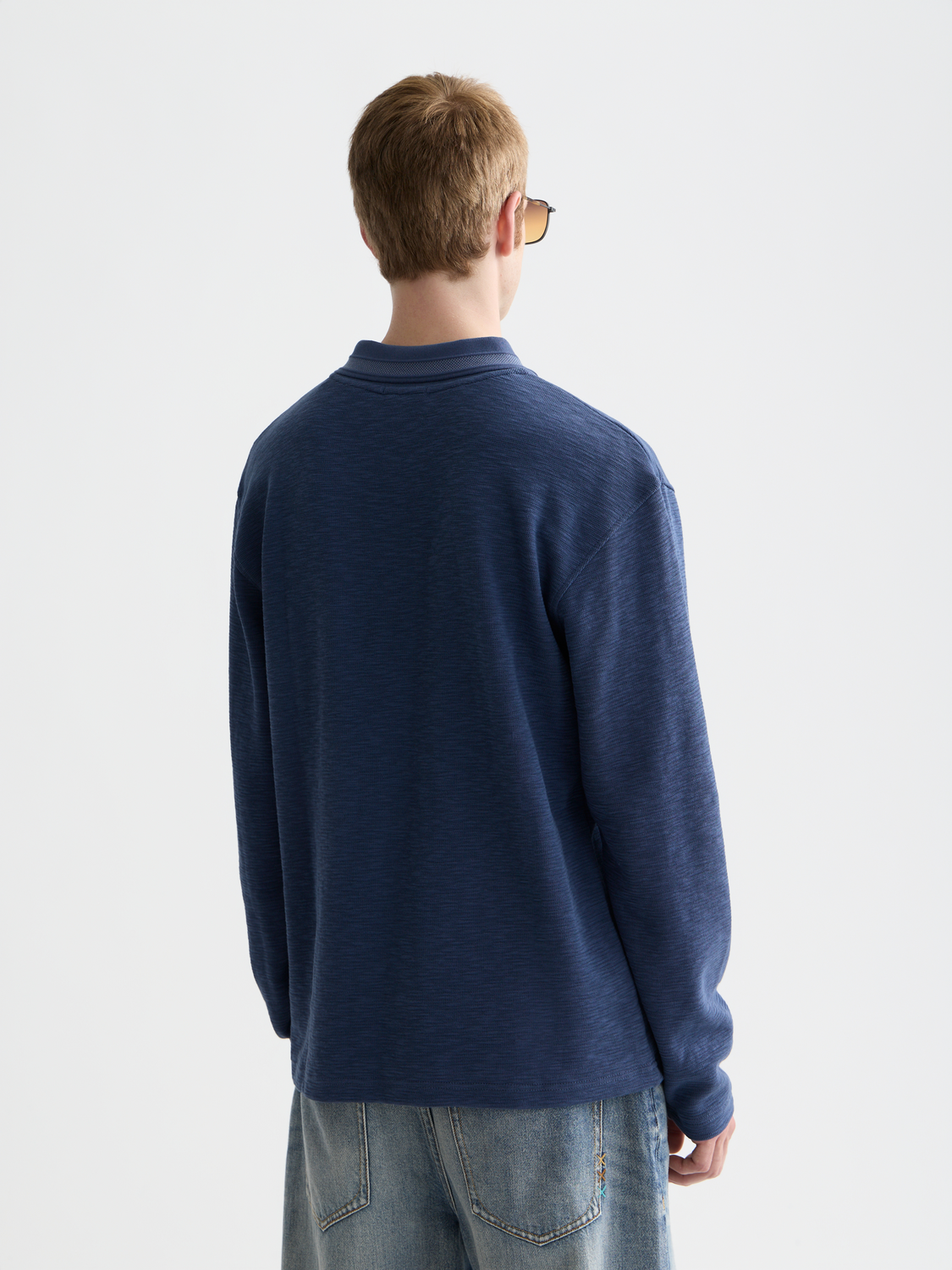 Long-sleeved Scotch & Soda polo shirt in dark blue with a classic collar and buttoned placket, shown from the back.