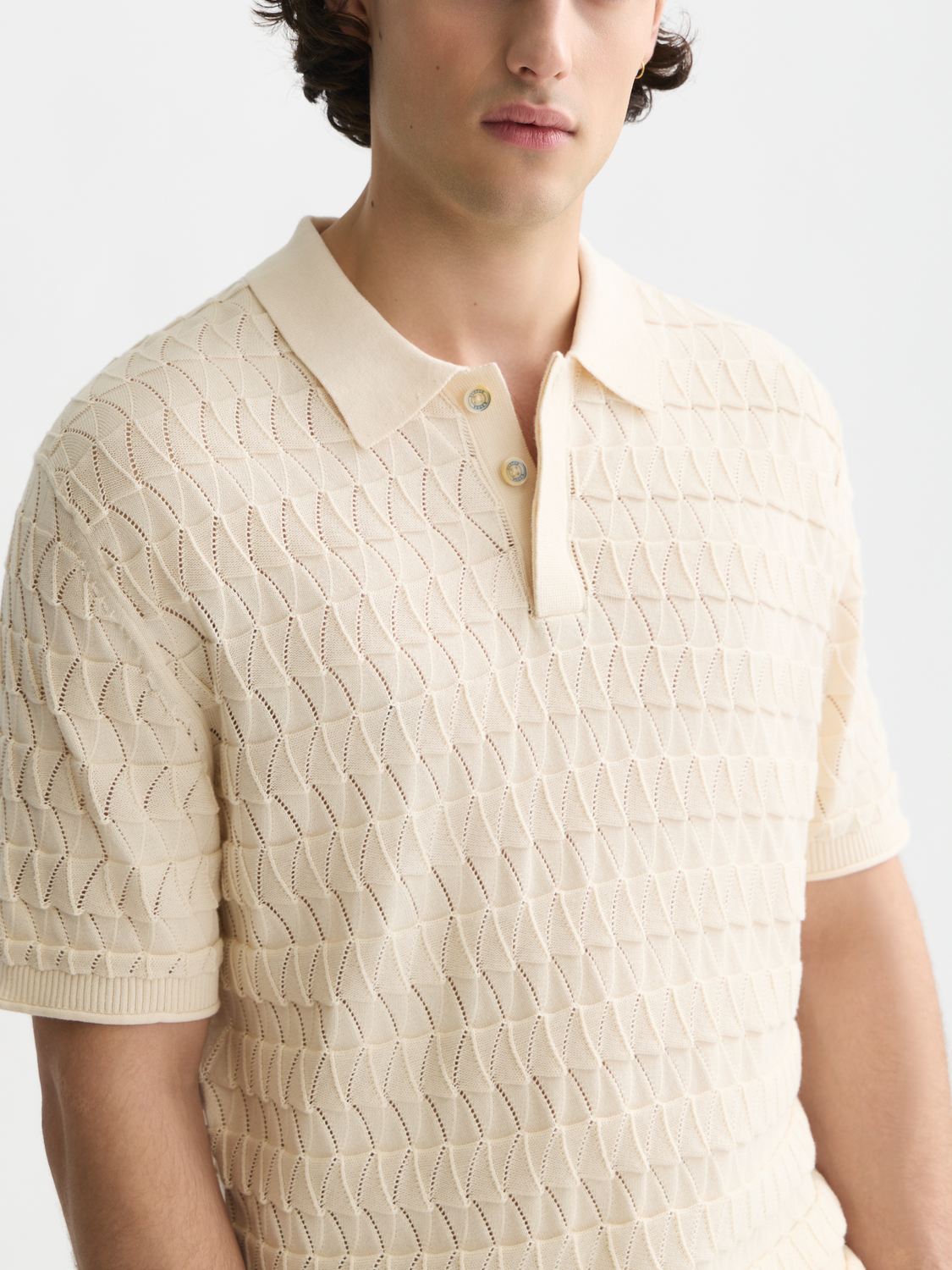 Scotch & Soda knitted polo shirt with a classic collar and textured knit fabric, shown in a close-up view.