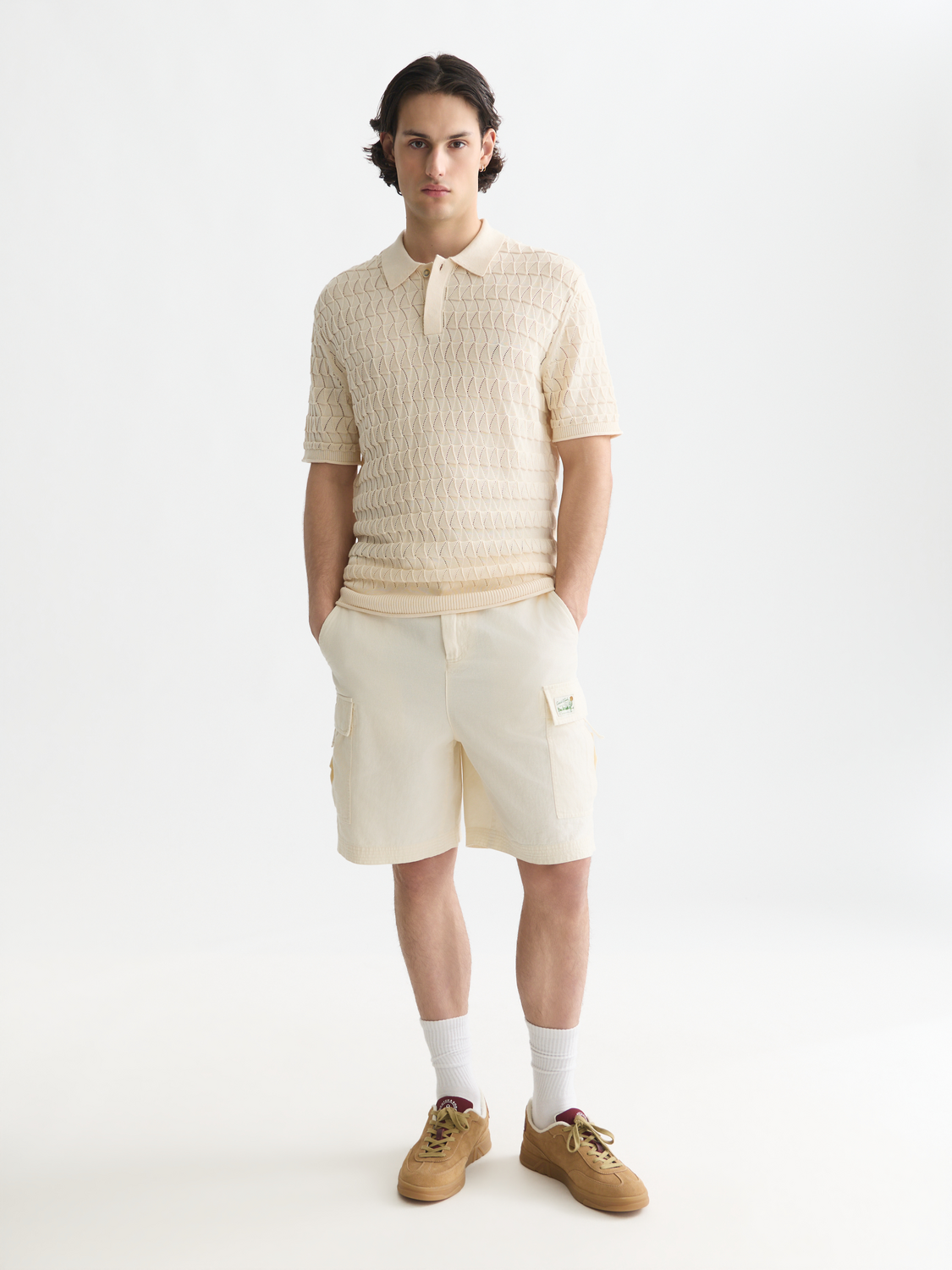 White knitted polo shirt by Scotch & Soda with a classic collar and short sleeves, displayed on a plain background.